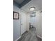 Hallway leading to a bathroom, featuring wood-look floors and neutral walls at 19029 Us Highway 19 N # 12E, Clearwater, FL 33764