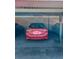 Covered parking structure featuring parked cars, including a red sedan, with ceiling supports and storage space at 19029 Us Highway 19 N # 12E, Clearwater, FL 33764