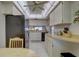 Well-lit kitchen featuring white cabinetry, a black refrigerator, and a view into the dining area at 2131 Ridge S Rd # 132, Largo, FL 33778