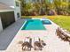 Aerial view of the pool with a spa, lounge chairs, and an outdoor dining area in the spacious backyard at 2216 Clement Rd, Lutz, FL 33549