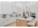 Modern kitchen with white cabinets, an island with seating and stainless steel appliances at 2216 Clement Rd, Lutz, FL 33549