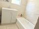 Bathroom features a vanity with a sink and a tub with tiled walls at 2410 Harper St, Tampa, FL 33605