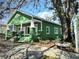 Green home with a charming front porch and lush landscaping at 2410 Harper St, Tampa, FL 33605