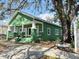 Green house with columns and a mature tree at 2410 Harper St, Tampa, FL 33605
