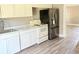 Kitchen with white cabinets, stainless-steel refrigerator, and stove at 2410 Harper St, Tampa, FL 33605