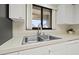 Well-lit kitchen featuring stainless steel sink and white cabinets at 2576 Laurelwood Dr # 13C, Clearwater, FL 33763
