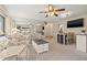 Bright living room with a ceiling fan, mirror wall and neutral carpet offers a cozy spot for relaxation at 2576 Laurelwood Dr # 13C, Clearwater, FL 33763