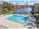 An aerial view of the community pool features lounge chairs and tables by the lake at 2576 Laurelwood Dr # 13C, Clearwater, FL 33763