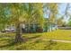 Charming home featuring a covered porch, a well-maintained lawn, and mature trees at 313 Jefferson S Ave, Oldsmar, FL 34677