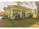 Charming light green single-story home with a covered front porch and mature landscaping at 313 Jefferson S Ave, Oldsmar, FL 34677
