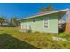 Exterior side view featuring a well-maintained yard, a small deck, and a cozy design at 313 Jefferson S Ave, Oldsmar, FL 34677