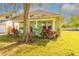 Charming light green single-story home with a covered front porch, swing, and mature landscaping at 313 Jefferson S Ave, Oldsmar, FL 34677