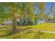 Charming home featuring a covered porch, a well-maintained lawn, and mature trees at 313 Jefferson S Ave, Oldsmar, FL 34677