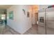 Hallway with stainless steel refrigerator, wood-look laminate flooring, and decorative artwork at 313 Jefferson S Ave, Oldsmar, FL 34677