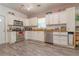 Spacious kitchen with white cabinets, stainless steel appliances, and wood-look laminate floors at 313 Jefferson S Ave, Oldsmar, FL 34677
