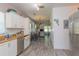View of kitchen with white cabinetry, granite countertops, and view to living room at 313 Jefferson S Ave, Oldsmar, FL 34677