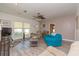 Cozy living room with neutral walls, light gray wood-look floors, and ample sunlight from large windows at 313 Jefferson S Ave, Oldsmar, FL 34677