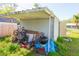 Covered outdoor storage area holding an assortment of equipment, including bicycles and a grill at 313 Jefferson S Ave, Oldsmar, FL 34677