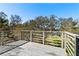 Back porch featuring wood floors, gray rails, and a picturesque view of the grounds at 3327 Pineview Dr, Holiday, FL 34691
