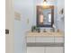 Bathroom vanity with a neutral countertop, modern faucet, decorative accents, and a framed mirror at 3327 Pineview Dr, Holiday, FL 34691