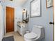 Cozy bathroom featuring a toilet, wood door, and window for natural light at 3327 Pineview Dr, Holiday, FL 34691