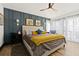 Stylish bedroom featuring an accent wall, hardwood floors, and large window with sheer curtains at 3327 Pineview Dr, Holiday, FL 34691