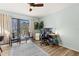 Relaxing bedroom with a ceiling fan, workspace, natural light, and access to outdoor balcony at 3327 Pineview Dr, Holiday, FL 34691