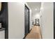 Hallway featuring light wood floors, a dark wood door, and a peek at the laundry machines at 3327 Pineview Dr, Holiday, FL 34691