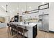 Modern kitchen features a large marble island, stainless steel appliances, and sleek white cabinetry at 3327 Pineview Dr, Holiday, FL 34691