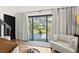 Bright living room with sliding glass doors opening to a waterfront deck with outdoor seating at 3327 Pineview Dr, Holiday, FL 34691