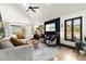 Bright living room featuring a modern ceiling fan, TV, sleek black wall, and ample natural light at 3327 Pineview Dr, Holiday, FL 34691