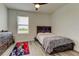 Cozy bedroom featuring wood-look floors, a rustic bed frame, and a bright window at 34110 Jasper Stone Dr, Wesley Chapel, FL 33543
