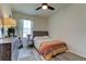 Well-lit bedroom with neutral walls, ceiling fan, dresser with mirror, and inviting bed with colorful quilt at 34110 Jasper Stone Dr, Wesley Chapel, FL 33543