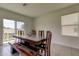 Dining room features a dark wood table with chairs and a bench near sliding glass doors at 34110 Jasper Stone Dr, Wesley Chapel, FL 33543