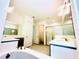 Bright bathroom featuring double vanities, a soaking tub, and a glass enclosed shower at 3444 Acacia Bay Ave, Wesley Chapel, FL 33543