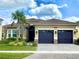 Beautiful single-story home showcasing a well-manicured lawn and three-car garage and detailed roof at 3444 Acacia Bay Ave, Wesley Chapel, FL 33543