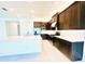 Bright kitchen featuring stainless appliances, a large kitchen island with white countertops and dark wood cabinets at 3444 Acacia Bay Ave, Wesley Chapel, FL 33543