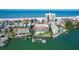 Aerial view of waterfront condos with boat docks, lush landscaping, a pool, and direct beach access at 3805 Gulf Blvd # 404, St Pete Beach, FL 33706