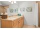 Bright bathroom featuring a single sink vanity with beige countertops and decorative beach-themed artwork at 3805 Gulf Blvd # 404, St Pete Beach, FL 33706