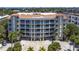 Stunning condo building featuring a terracotta roof, white accents and multiple levels of balconies overlooking lush landscaping at 3805 Gulf Blvd # 404, St Pete Beach, FL 33706