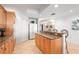 Well-lit kitchen with breakfast bar, light wood cabinetry, granite countertops, and stainless steel refrigerator at 3805 Gulf Blvd # 404, St Pete Beach, FL 33706