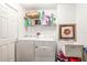Functional laundry room featuring a side-by-side washer and dryer, utility sink, and ample shelving space at 3805 Gulf Blvd # 404, St Pete Beach, FL 33706