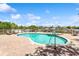Community pool with a separate jacuzzi area overlooking the bay, complete with brick pavers and lounge chairs at 3805 Gulf Blvd # 404, St Pete Beach, FL 33706