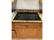 Sleek electric stovetop with granite countertop and warm wood cabinets in this well-equipped kitchen at 3805 Gulf Blvd # 404, St Pete Beach, FL 33706