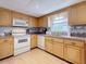 Functional kitchen featuring wooden cabinets, white appliances, and a stainless steel sink at 504 Cara Ct # 504, Largo, FL 33771