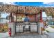 Outdoor grill area with a thatched roof, including two stainless steel grills and safety signs at 5267 81St N St # 18, St Petersburg, FL 33709