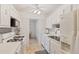 Bright kitchen with white cabinetry, stainless steel sink, and mosaic backsplash, all illuminated by a ceiling fan at 5267 81St N St # 18, St Petersburg, FL 33709