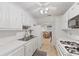 A classic-style kitchen showcasing white cabinets, modern appliances, and a view into the living area at 5267 81St N St # 18, St Petersburg, FL 33709