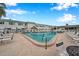 Community pool surrounded by lounge chairs, shade umbrellas, and lush landscaping at 5267 81St N St # 18, St Petersburg, FL 33709