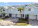 Modern townhome features a garage, lush landscaping, and inviting curb appeal at 649 Garland Cir, Indian Rocks Beach, FL 33785